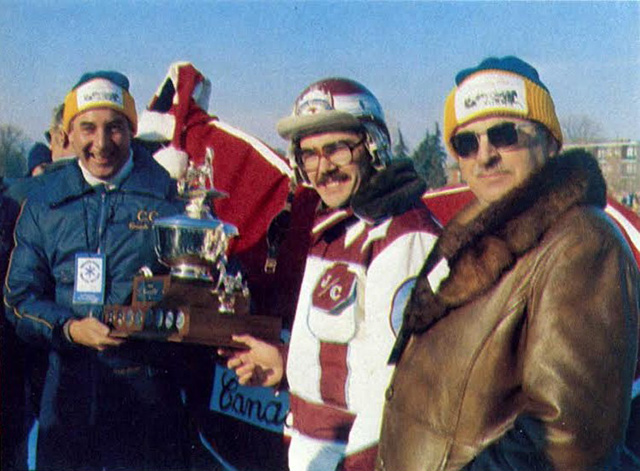 Three men surrounding a trophy