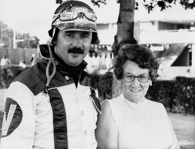 A driver in racing colours alongside a woman