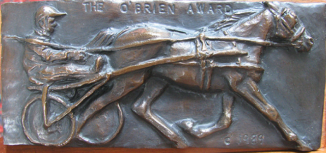 A bronze trophy showing a horse and driver with "The O'Brien Award 1989" imprinted