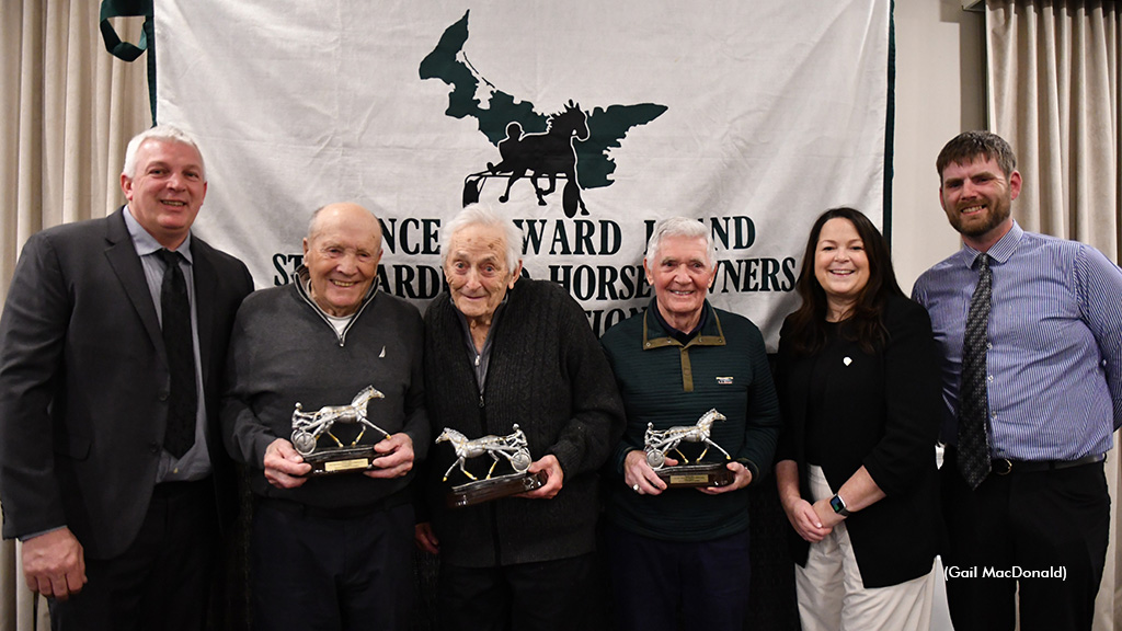Three award winners hold trophies flanked by three other people