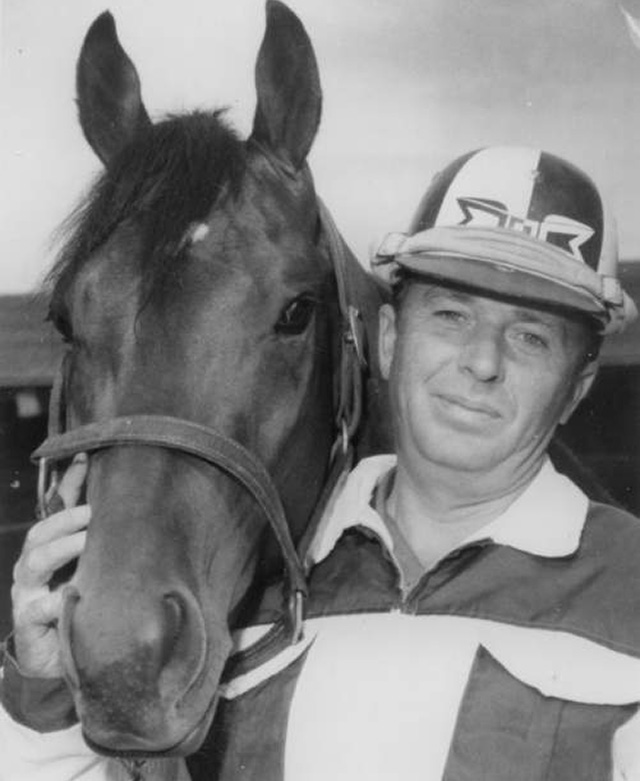 Jack Kopas stands holding a horse's head