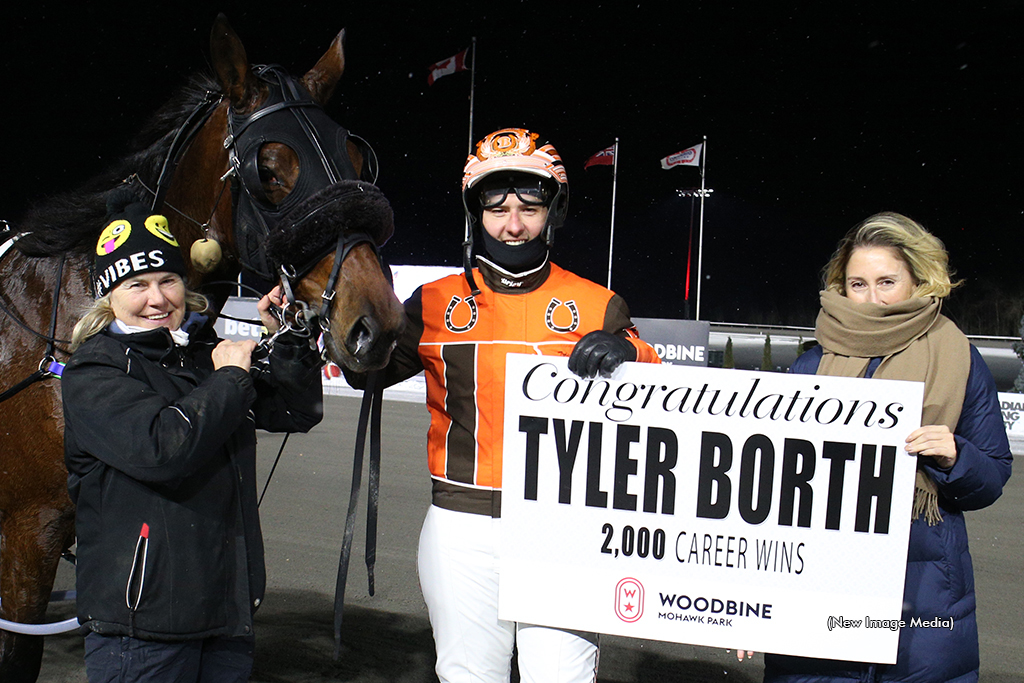 Tyler Borth celebrates his 2,000th career driving win in the winner's circle with Mikki Sixx and trainer Susie Kerwood