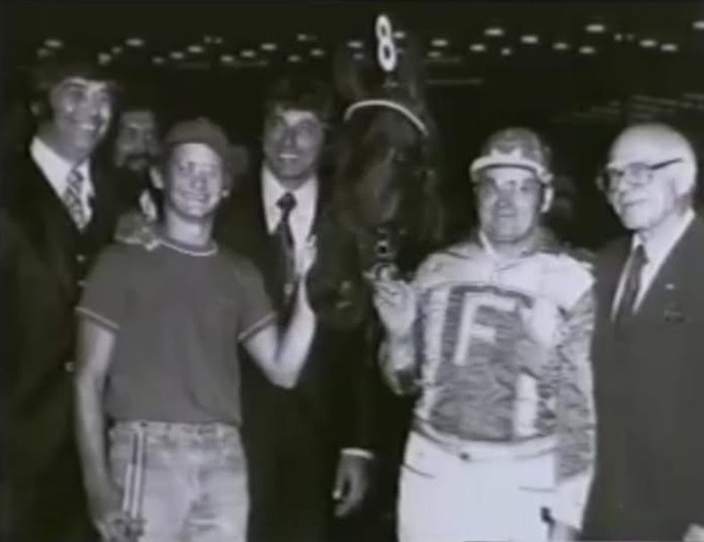 A group of people and horse in the winner's circle