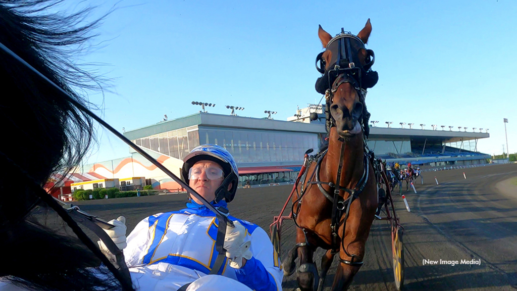 James MacDonald in the sulky leading the field into the turn at Mohawk