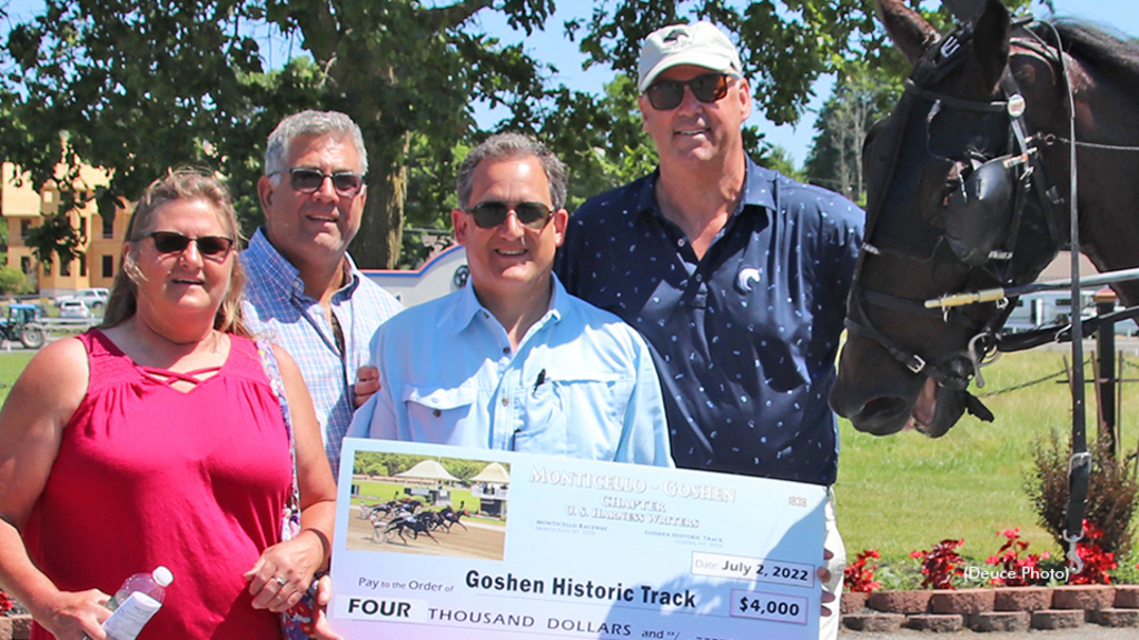 Chris Tully presents a cheque for $4,000 to Goshen Historic Track president Steve Jones, who is holding track record-setting JD. 