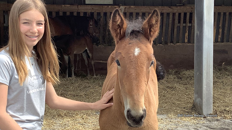 A girl and foal pose for a photo at the Tom Rankin Open House