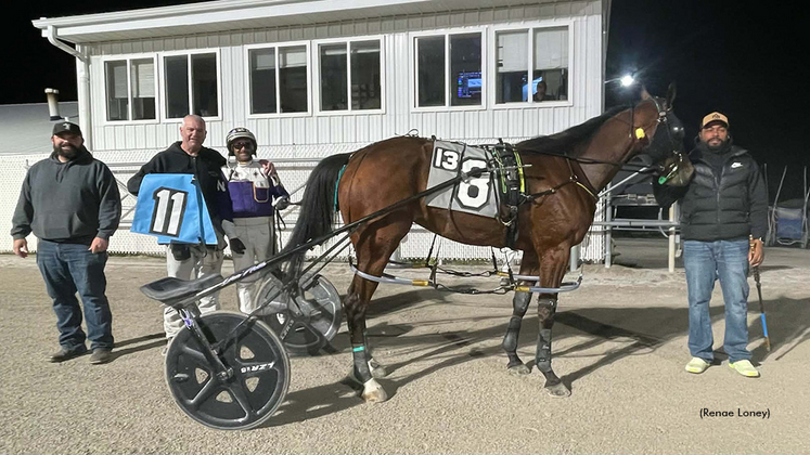 Dan Noble next to his horse after winning his 11th race, with an 11 saddle cloth being displayed